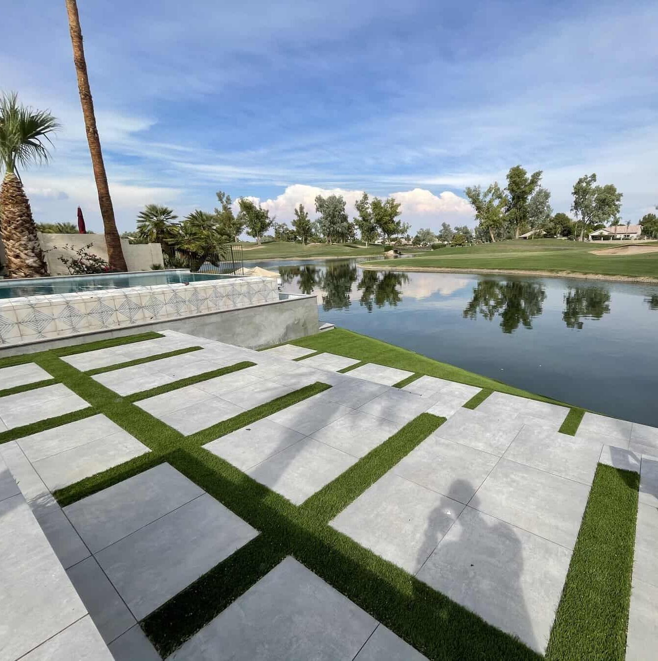 Large square concrete pavers with artificial turf strips in between each paver, next to a golf course at a home in Pheonix AZ