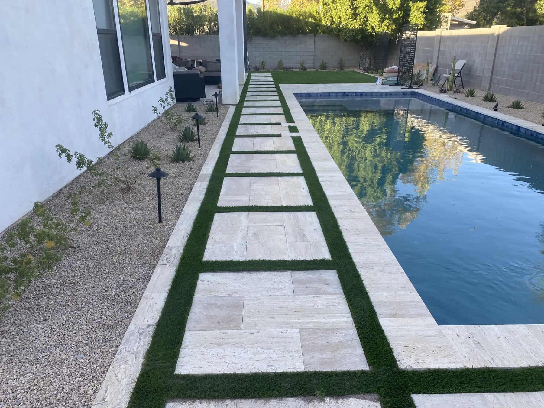 limestone pavers patio installed next to a blue tiled pool. Installed by Apex Turf at a home in Phoenix AZ