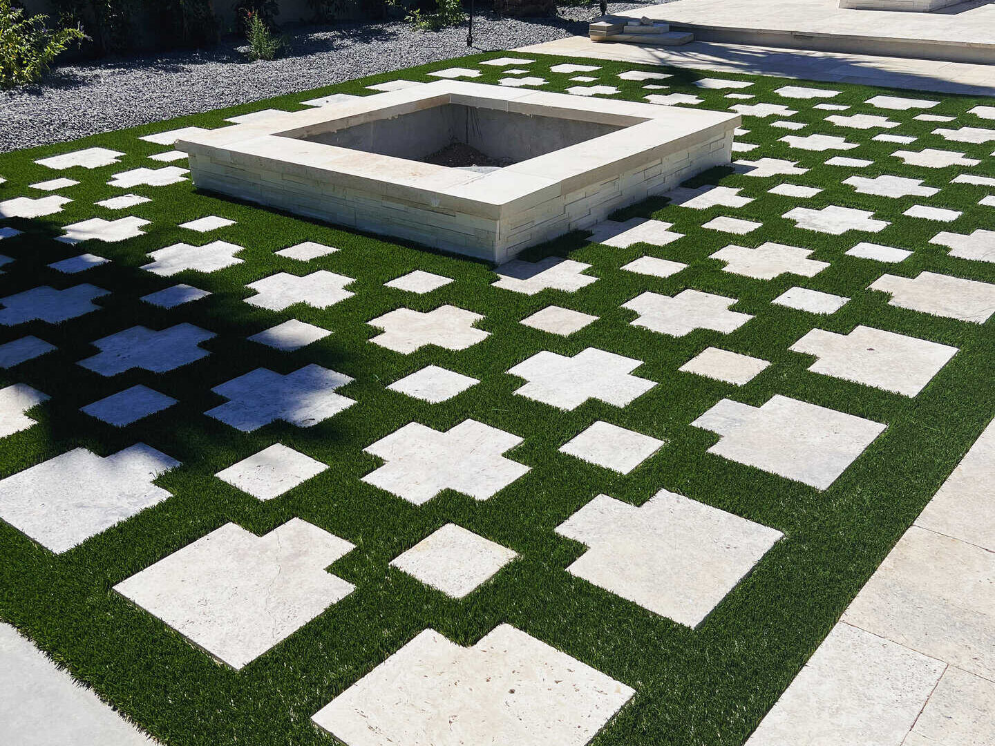 Geo-grid pattern pavers and artificial turf in a grid format. Fire pit in the middle