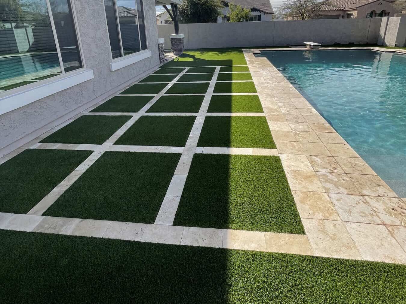 Artificial grass squares with pavers in between next to a pool deck in Phoenix AZ. Installed by Apex Turf
