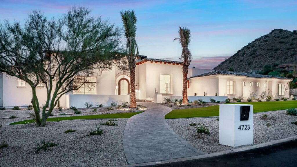 Grey paver walkway leading to a house lit up on dusk in Scottsdale Arizona