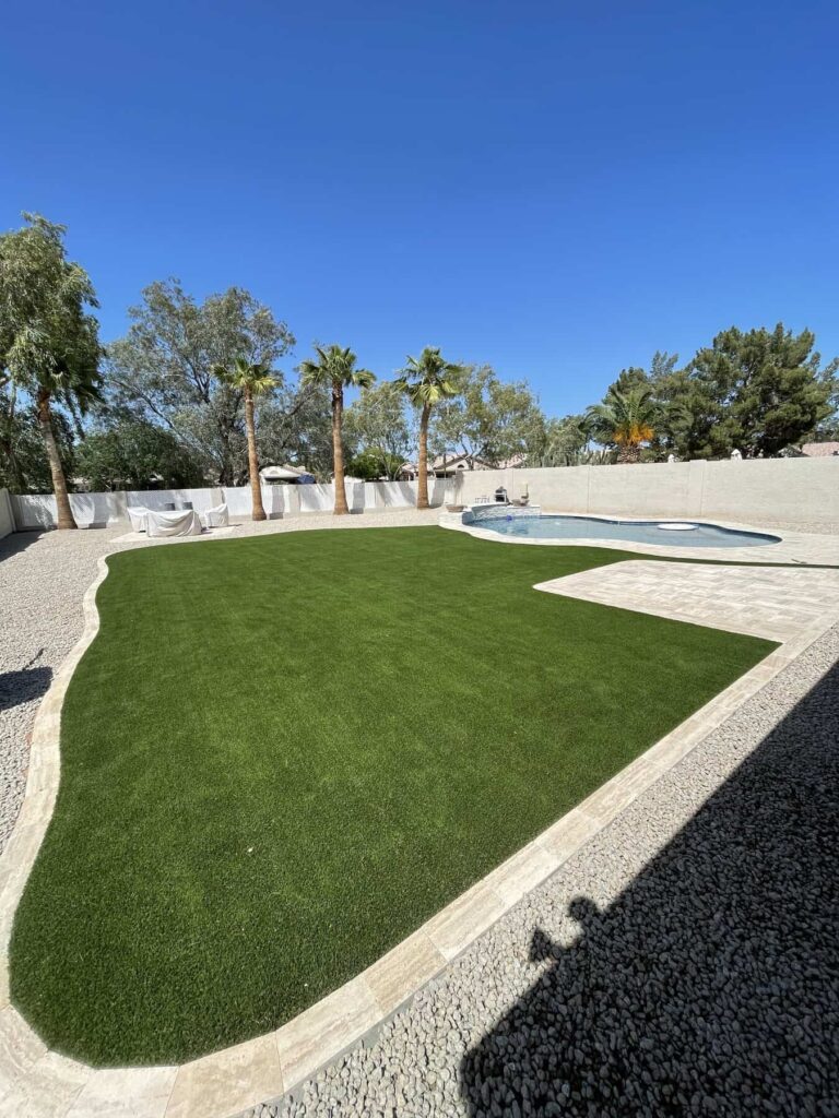 paver border and hardscaping around a large piece of kidney bean shaped artificial turf at a high end home in scottsdale arizona