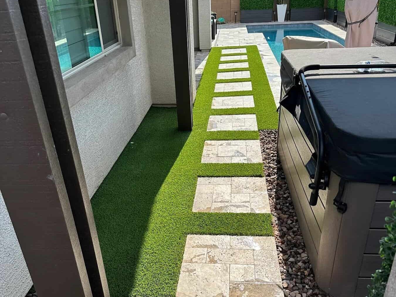 Paver and turf walkway leading from the back door to the pool area featuring a pool and Jacuzzi 