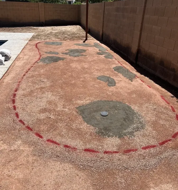 Backyard base prepared with compacted quarter minus stone, ready for synthetic turf to be installed on top