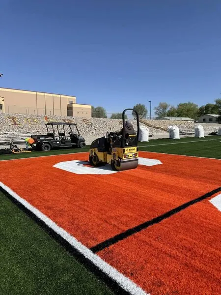 Roller operator rolling flat the astroturf for football on a new football field at Williams Elementary School in Williams AZ.