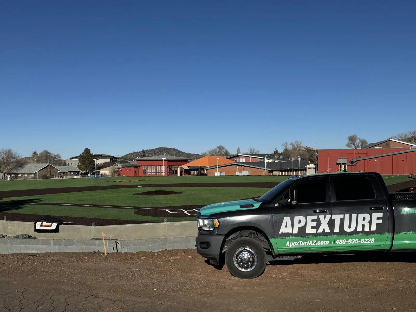 Picture of an Apex Turf pickup truck where a newly installed astroturf baseball field has just been completed. Field is for Williams Highschool in Williams, AZ