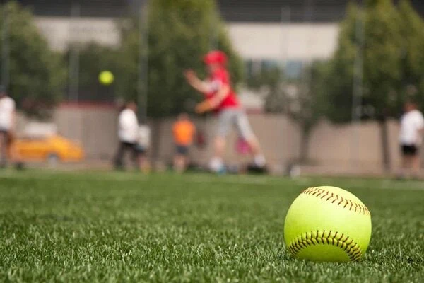 Softball lying on synthetic grass at a training facility