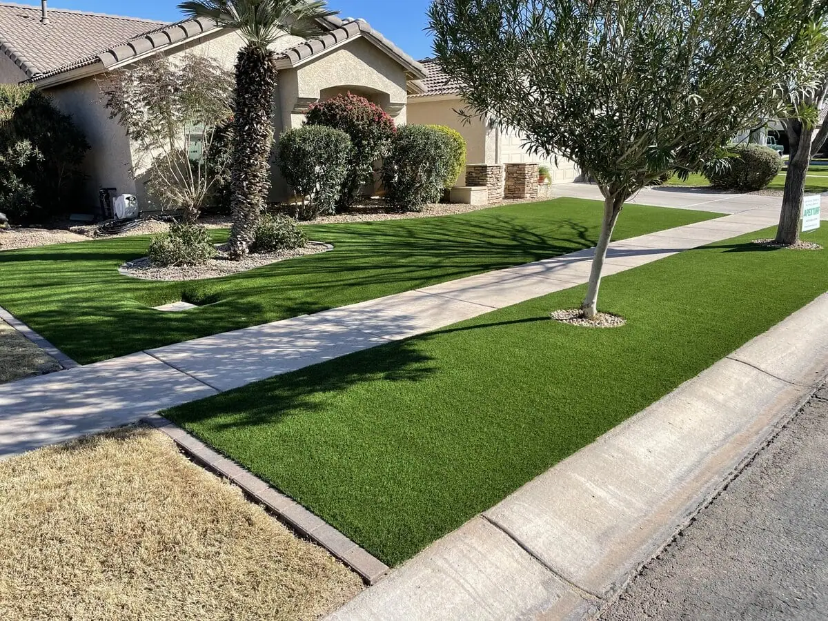 Artificial grass lawn with trees and landscape rock, in front of a home in Phoenix Arizona. Installed by Apex Turf.